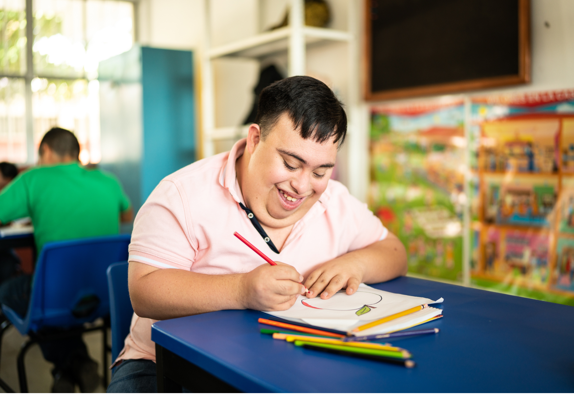 Young person with additional needs smiling and engaged in creative work at school